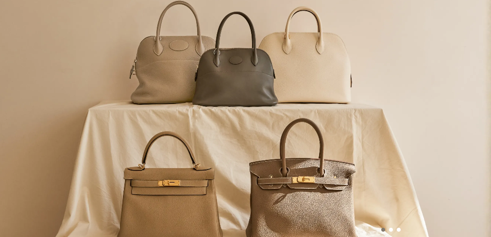 A warm editorial still life of designer handbags